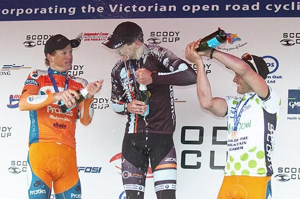 Stage winner Benjamin Hill (centre) of Jayco/2XU receives a spray from runner-up Patrick Shaw (left) of Genesys Wealth Advisers and third-placed Nathan Haas also of Genesys Wealth Advisers.