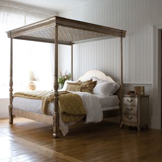 bedroom with four poster bed and white wood panel wall