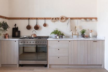 A small kitchen with light wood cabinets and white walls