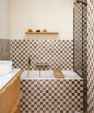 brown and cream checkerboard tiled bath with a wavy wooden vanity