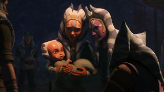 Still from the T.V. Star Wars: Tales of the Jedi. Baby Ahsoka is held in the arms of her mother, as her father looks over them both. They all have orange faces with white markings and blue and white stripped head tails, although baby Ahsoka's are very small.
