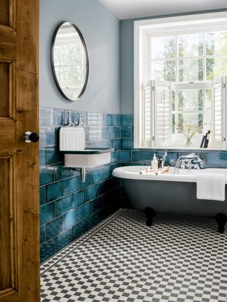 Luxury bathroom with chequered floor tiles, blue wall tiles and blue wall paint decor