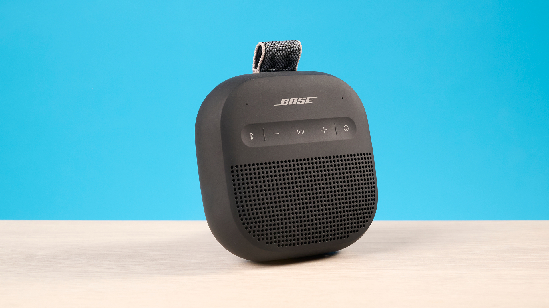 Bose SoundLink Micro 2 in black photographed in front of a blue background