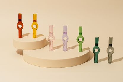 Different coloured marijuana smoking pipes on round platforms.