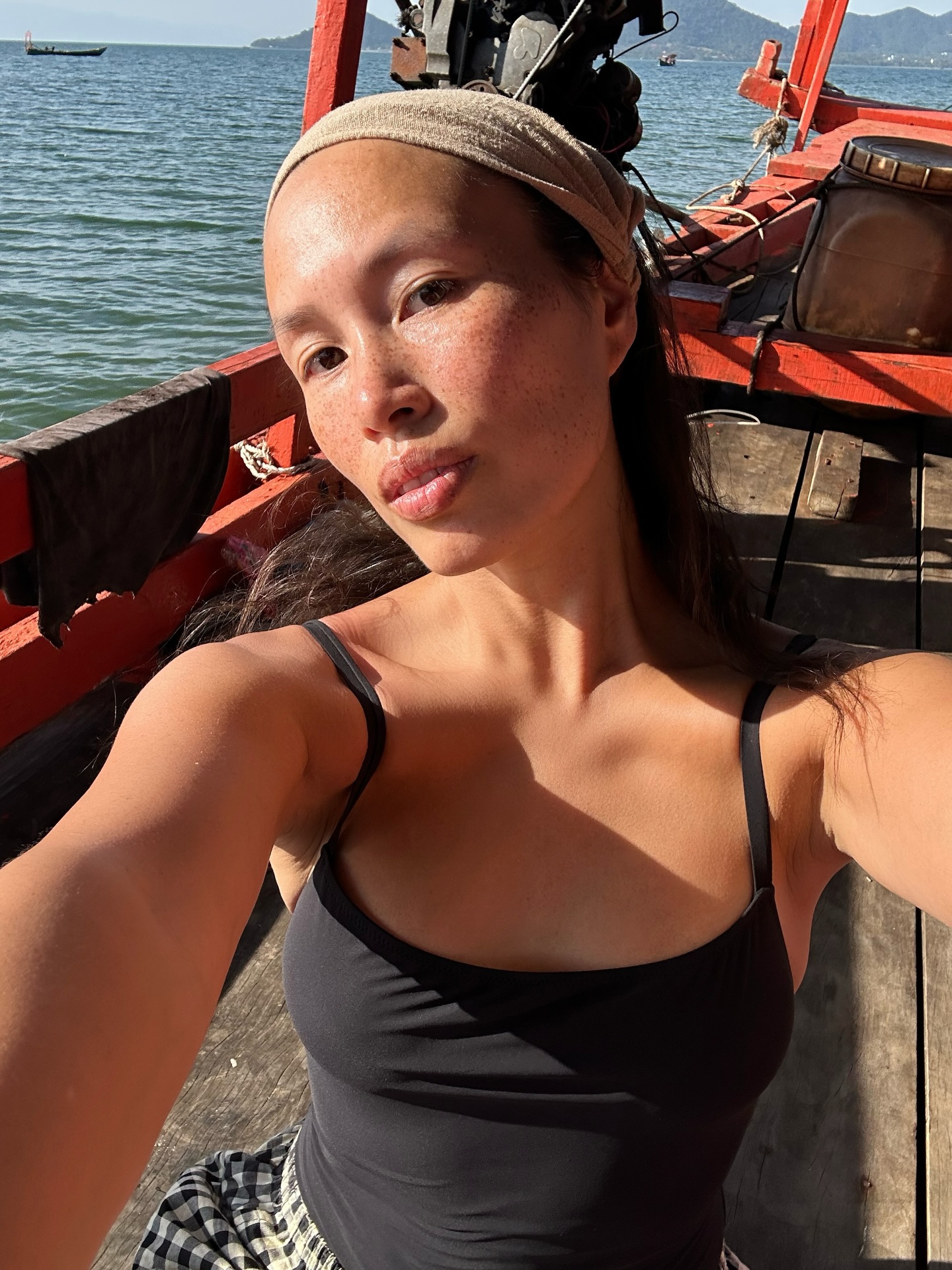 A woman with glowing skin on a boat.