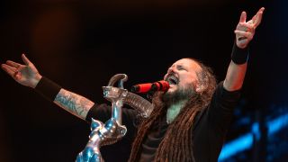 Jonathan Davis, arms outstretched on stage