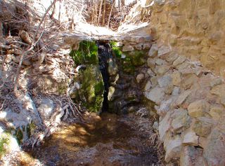 Just a few hundred yards west of the mountain's saddle, a natural spring of water (shown here) flowed year round.