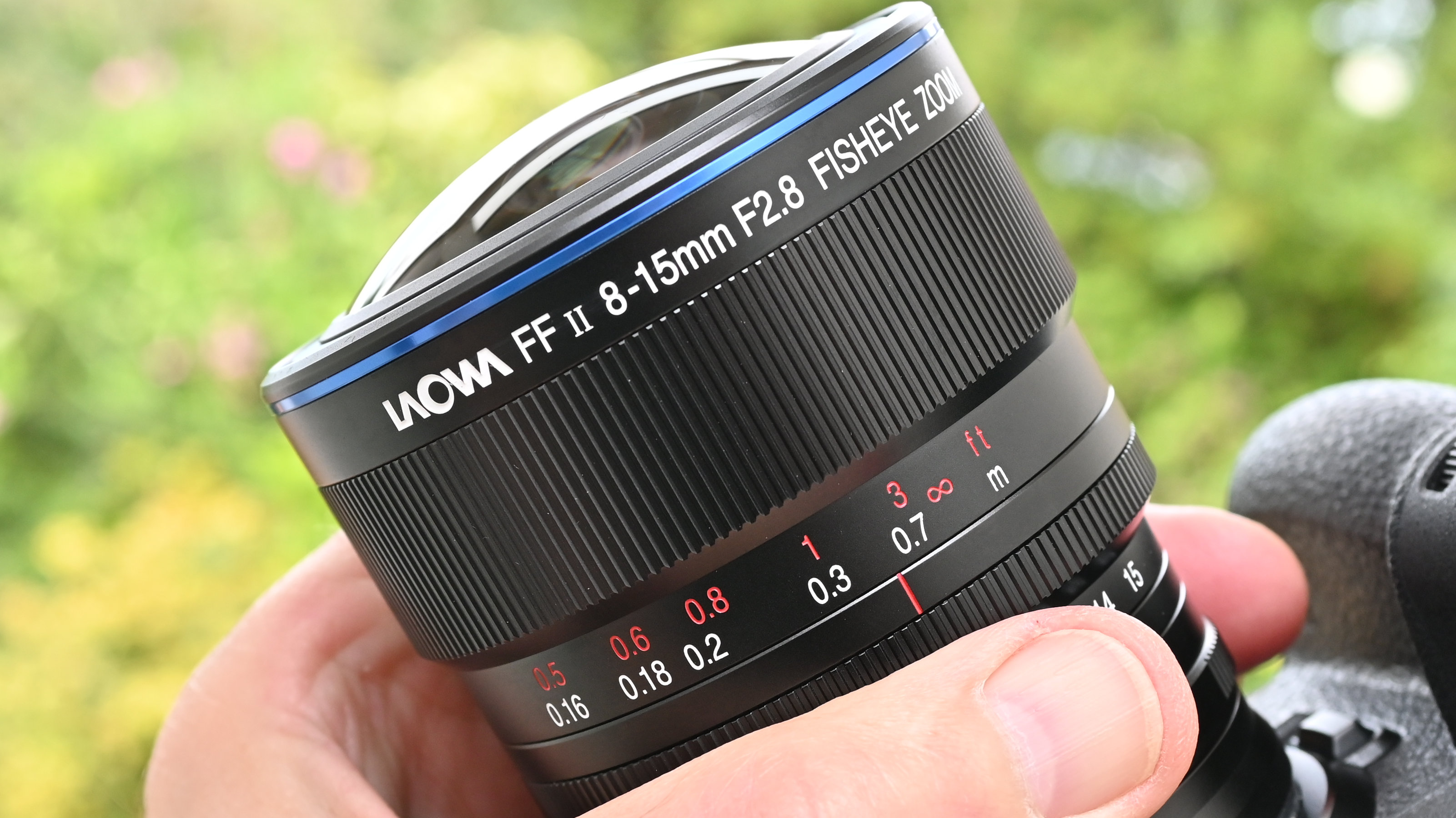 Laowa 8-15mm f/2.8 FF Zoom Fisheye product image of lens held in hand