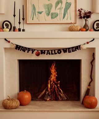 Ed Emberley Happy Halloween Garland on a mantel over a fire.