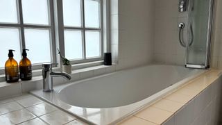 built-in bath with white tiled surround