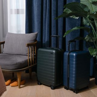 Bedroom with two carry-on suitcases standing next to a chair