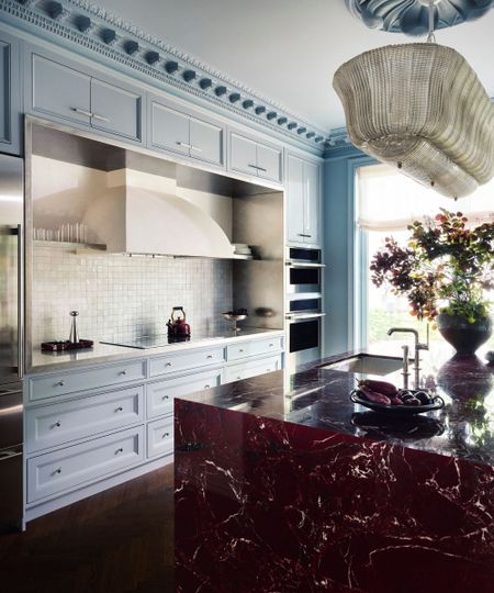 Kitchen with blue cabinets and a burgundy marble island 