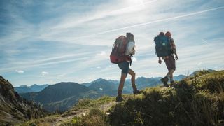 Two people hiking across a ridge