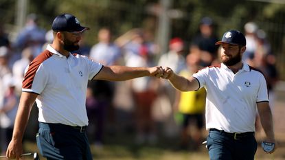 Jon Rahm and Tyrrell Hatton fist bump on the tenth green during the Saturday morning foursomes matches of the 2023 Ryder Cup
