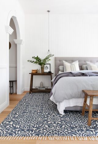 White bedroom design with blue patterned rug