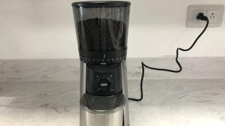 OXO grinder on a marble countertop, plugged in to the socket