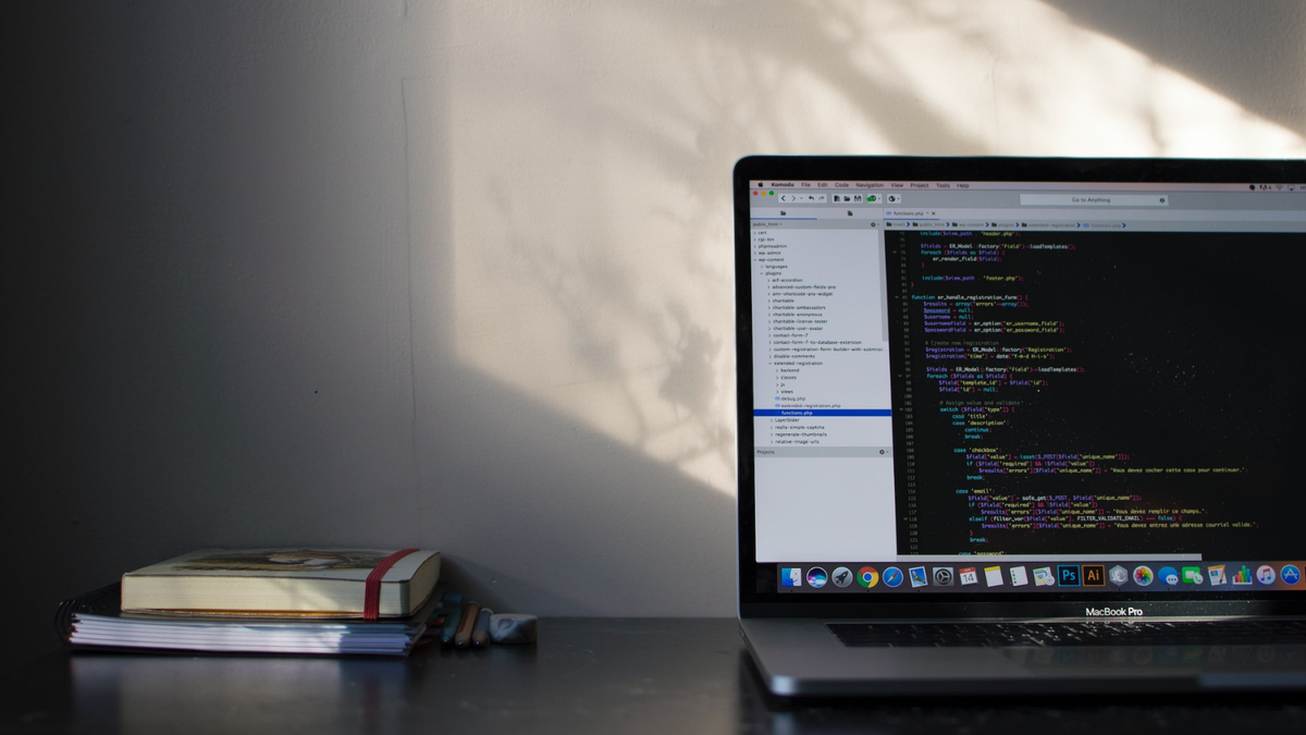 Macbook on a desk with coding displayed on screen