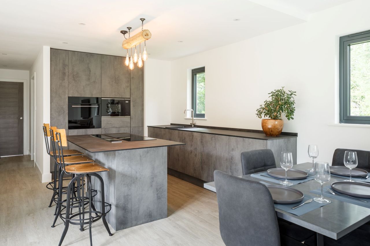 A grey kitchen-diner with a kitchen island with an induction hub inbuilt