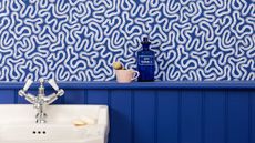 Small bathroom with blue patterned wallpaper and royal blue bathroom wall paneling