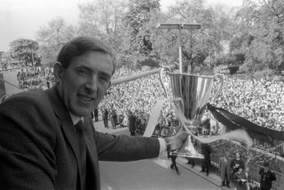 Tottenham captain Danny Blanchflower holds the European Cup Winners' Cup in front of a large crowd at a civic reception following Spurs' victory over Atletico Madrid in the final in May 1963.