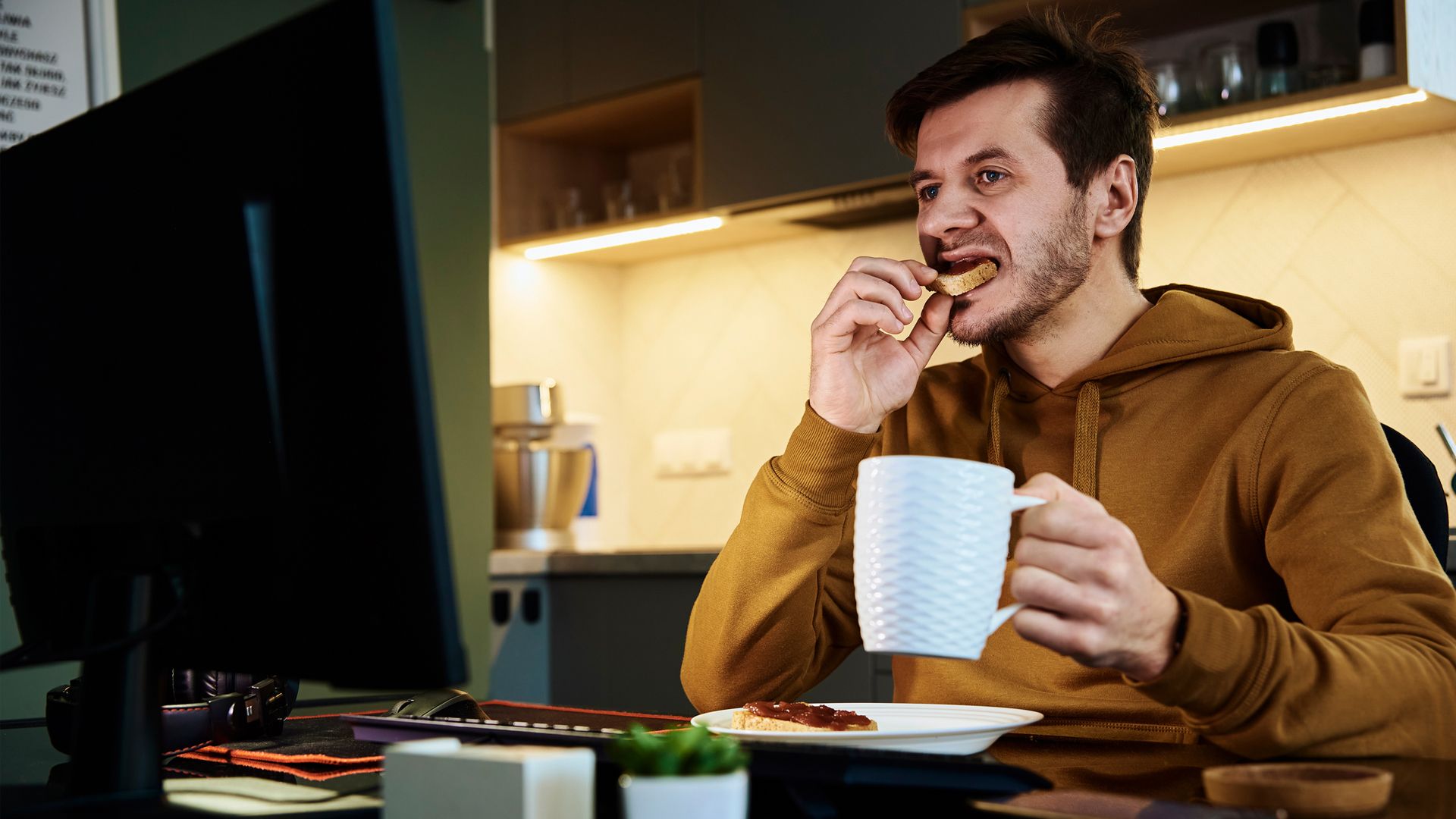 man eating at his desk late at night
