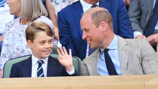 Prince George waving and smiling next to his father Prince William as they attend attend The Wimbledon Men's Singles Final the All England Lawn Tennis and Croquet Club on July 10, 2022 in London, England.