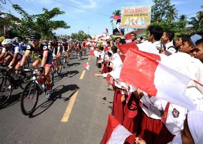 Elementary students in Payakumbuh support riders with paper flags on Stage 2