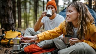 Couple making and drinking coffee at camp