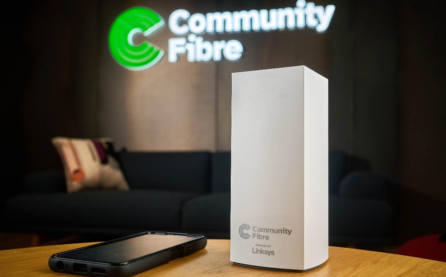Community Fibre router on a table, with the company logo behind