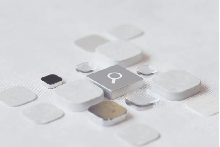 An abstract keyboard with a magnifying glass icon on the center key. 