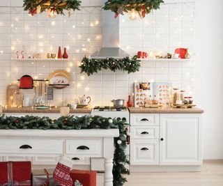 A kitchen with a white island and christmas decorations all around it