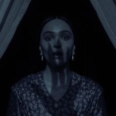 nosferatu still of lily-rose depp as ellen hutter gasping with a shadow of a hand over her face