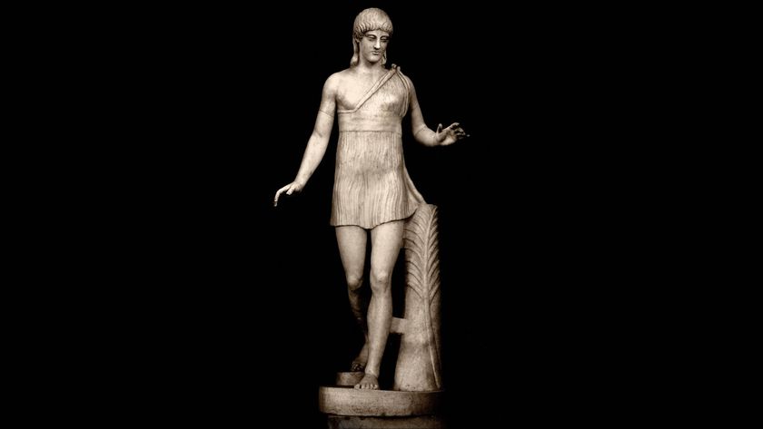 Photo of a statue of a woman in a jogging posture. She is depicted in bare feet and wearing a short dress. 