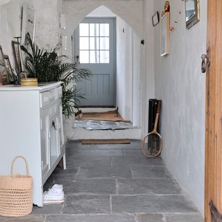 white hallway with stone flooring and laminated cupboard