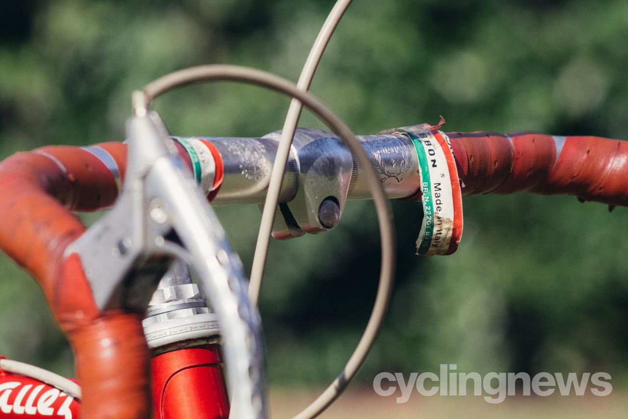 close up of vintage handlebars with torn bar tape and sagging cables