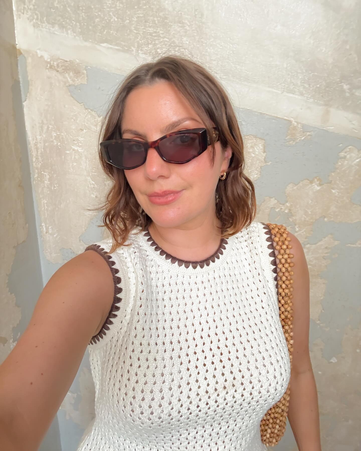 @emmahoareau taking a selfie on holiday in Greece with a soft, layered bob hairstyle
