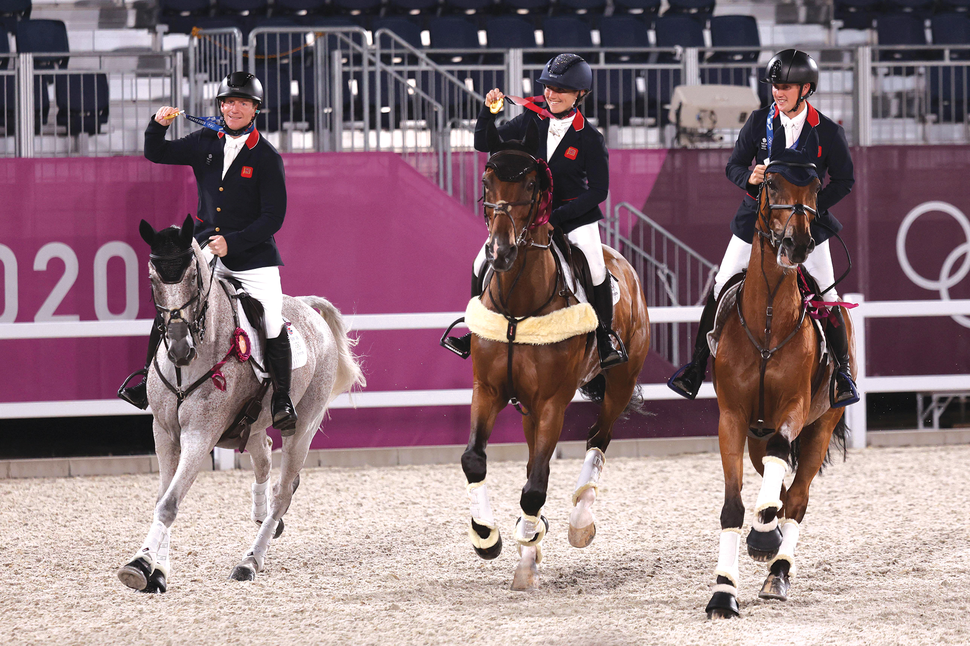 Oliver Townend riding Ballaghmor Class, Laura Collett on London 52 and Tom McEwen with Toledo De Kerser hold their gold medals aloft during their lap of honour at the Tokyo 2020 Olympics.