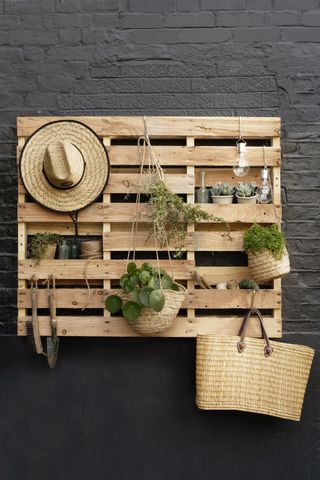 A wall mounted pallet used as a garden tidy
