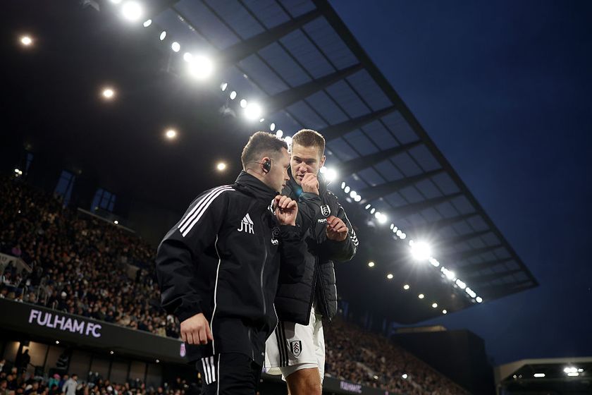 Joachim Andersen of Fulham leaves the pitch with a member of the backroom staff after picking up an injury before being substituted off during the Premier League match between Fulham and Arsenal at Craven Cottage on October 18, 2025 in London, England.