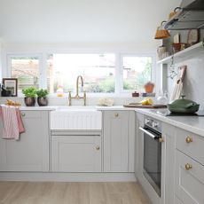 grey kitchen with white worktops and gold handles