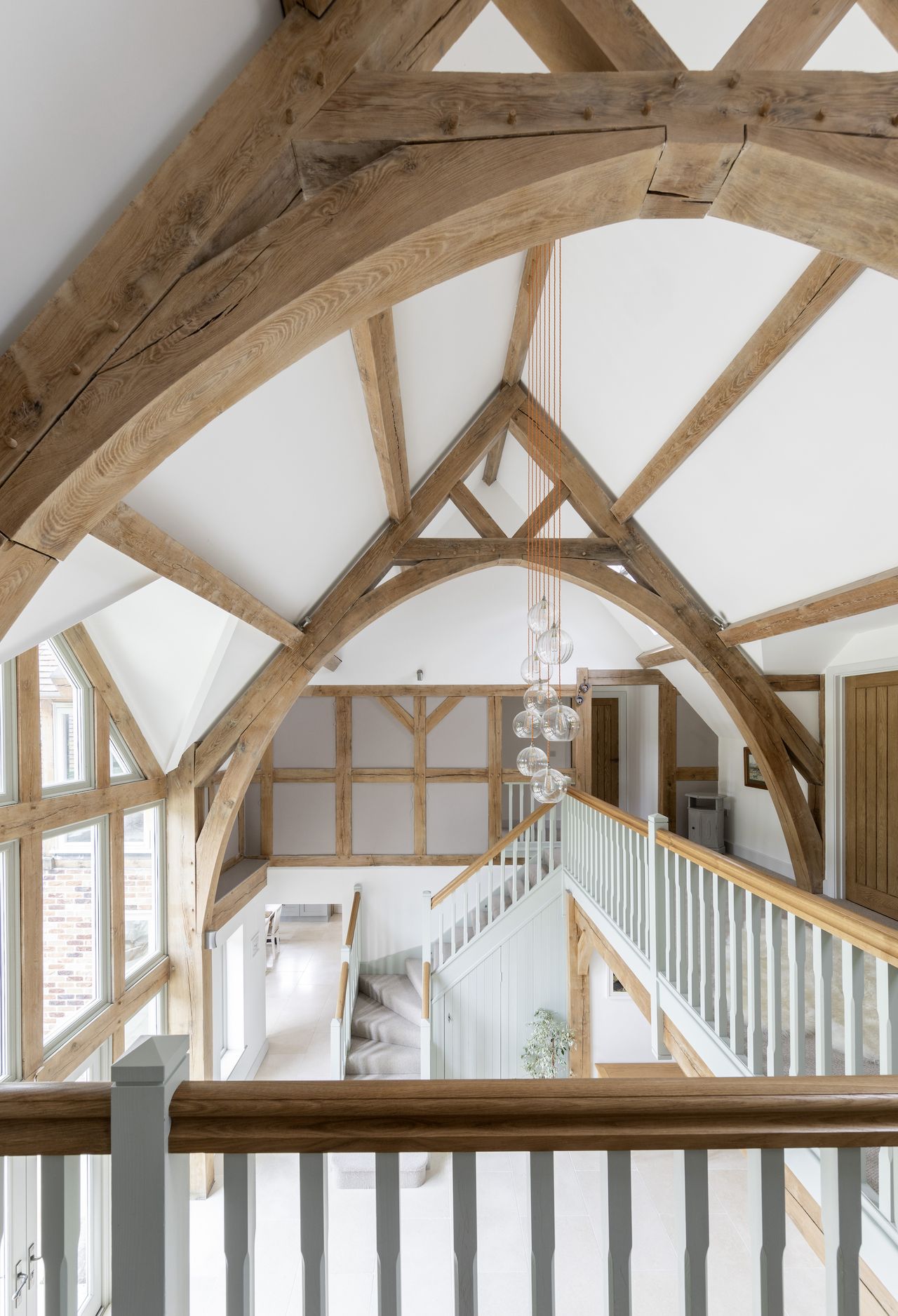 oak frame landing with vaulted ceiling and view of grand floor