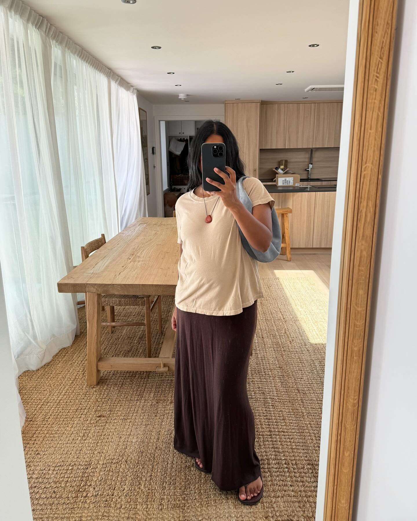 Influencer Monikh wears a brown jersey skirt with a beige slouchy tee.