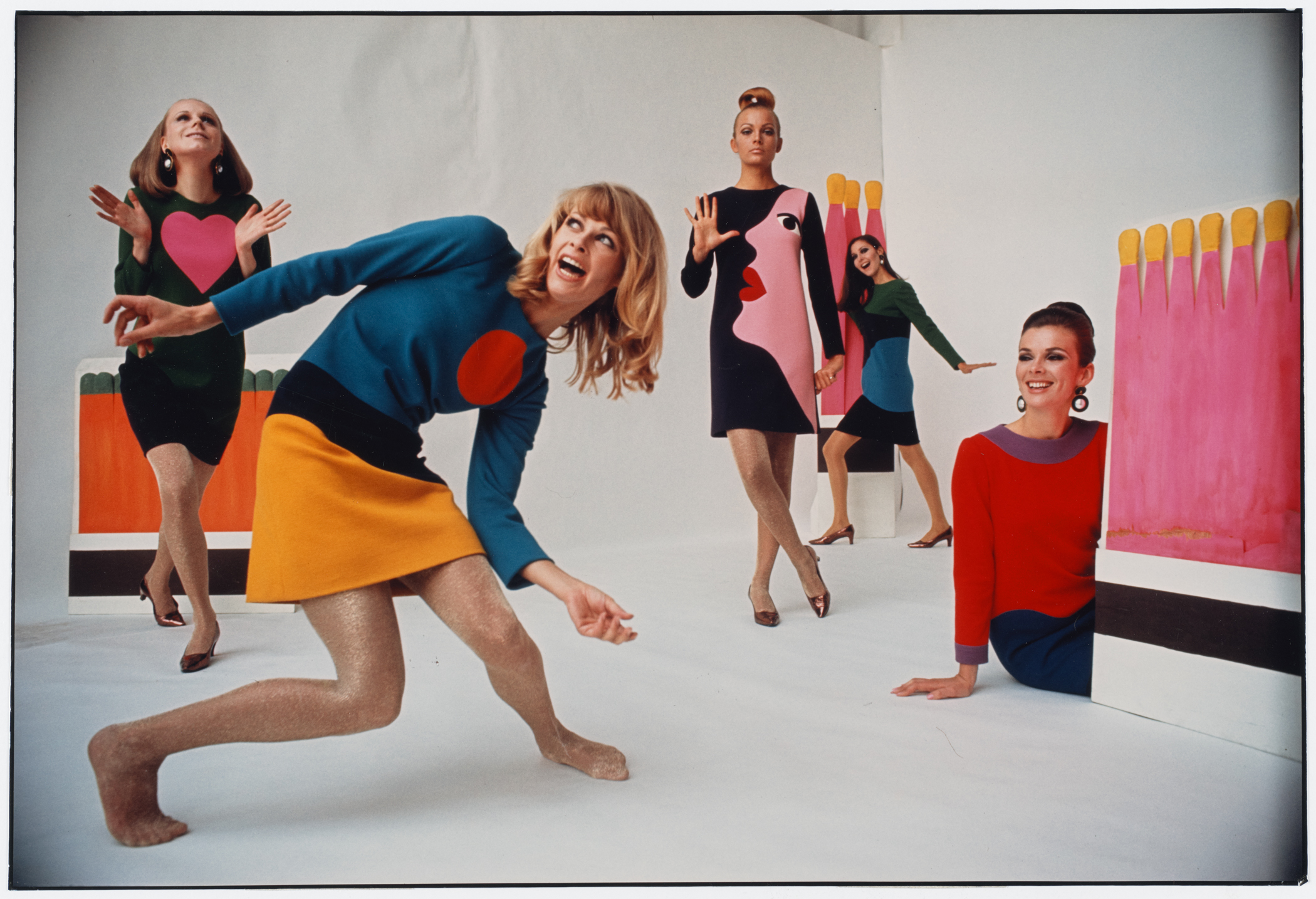 Four women posing wearing colorful clothing.
