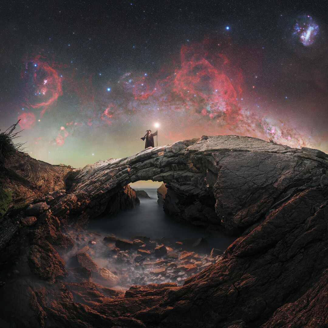 A glowing night sky image frames a wizard standing on a stone arch in the middle of the image