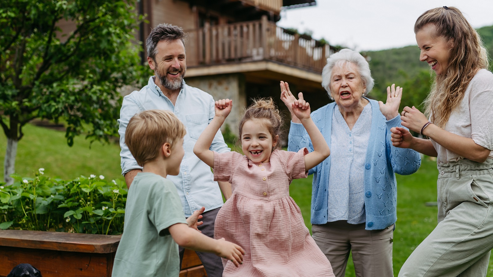 Three generations of a family play in the backyard.