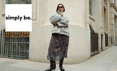 simply be logo top left with a woman standing posing with sunglasses on wearing a checkered mid skirt and coat