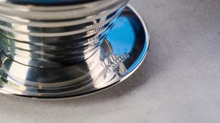 kalita wave stainless steel pour-over coffee dripper photographed against a blue background with kalita filters