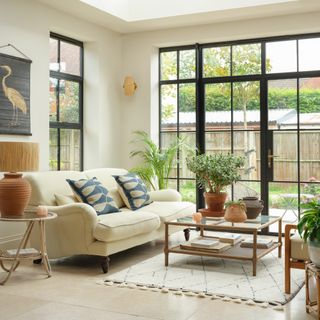 open plan living area with full height crittal-style windows and patio doors, tiled floor and rooflights