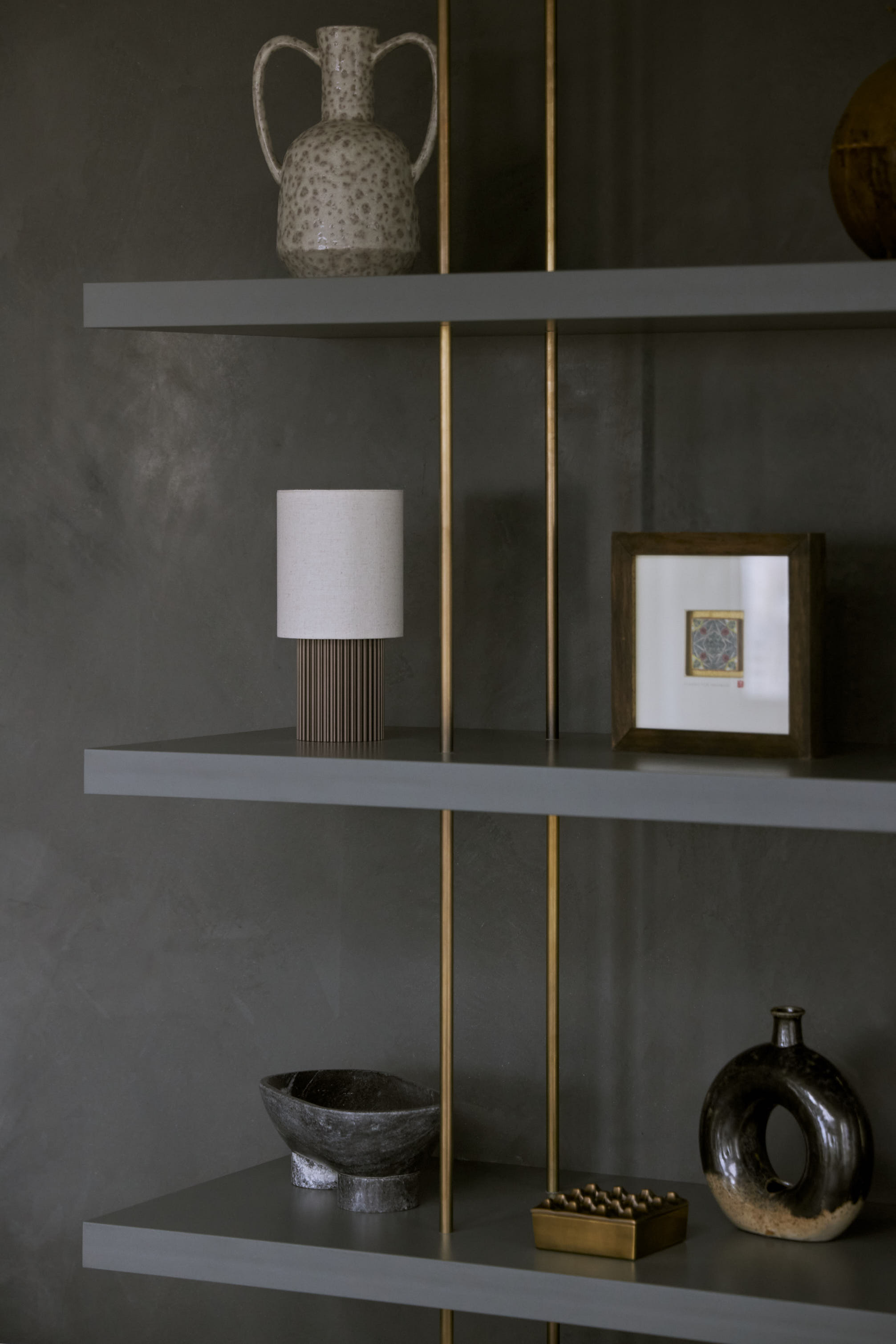 A contemporary living room shelf arranged with objects in a similar tonal palette