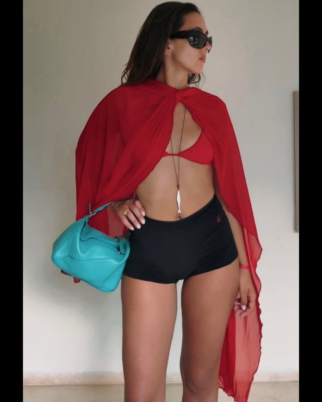Woman in red bikini and long fish necklace